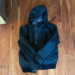 This is a black Roark jacket with a furry inside